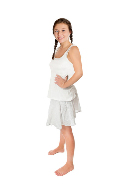 Full length portrait of a young woman with ponytails wearing a white top and a short summer skirt, isolated on white studio background - Foto, imagen