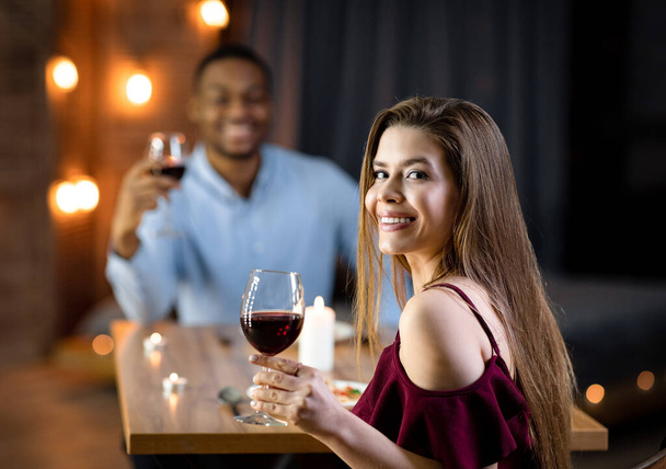 Празднование Дня Святого Валентина. Влюбленная межрасовая пара ужинает в ресторане - Фото, изображение