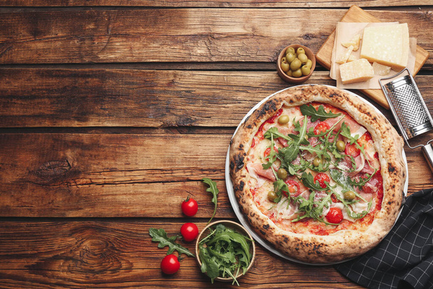 Tasty pizza with meat and arugula on wooden table, flat lay. Space for text - Foto, immagini