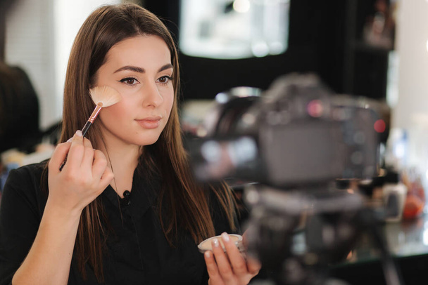 Mulher bonita nova e beleza profissional compõem o tutorial de maquiagem de gravação de artista vlogger em estúdio beuty para compartilhar no site ou nas mídias sociais. Blogger usar câmera digital no tripé e lâmpada anel - Foto, Imagem