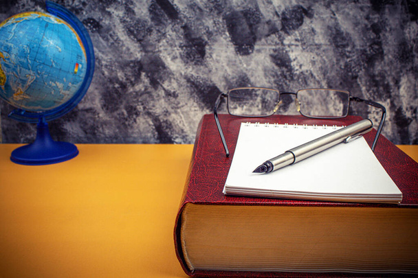 Libro e bicchieri con una penna sul tavolo. Sfondo con spazio per il testo - Foto, immagini
