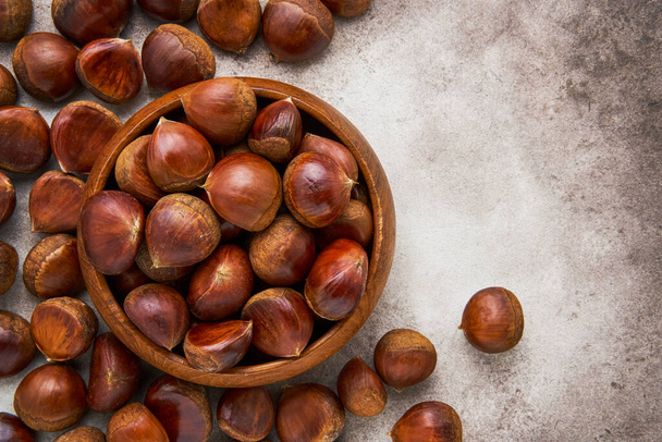 Pile of fresh sweet chestnuts in a bamboo bowl. Top view, copy space - Photo, Image