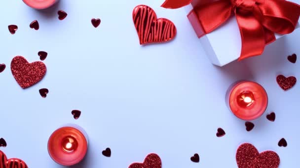 Valentijnsdag geschenkdoos, rode liefde harten, romantische kaars op witte achtergrond. Romantische berichtsjabloon met kopieerruimte. Bovenaanzicht. Uitzicht van bovenaf - Video