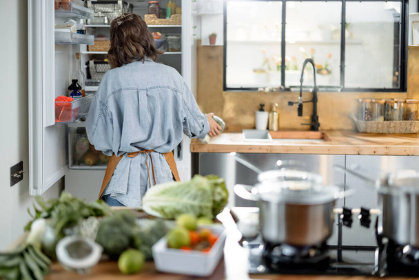 Woman staying back in the beautiful interior kitchen  - 写真・画像