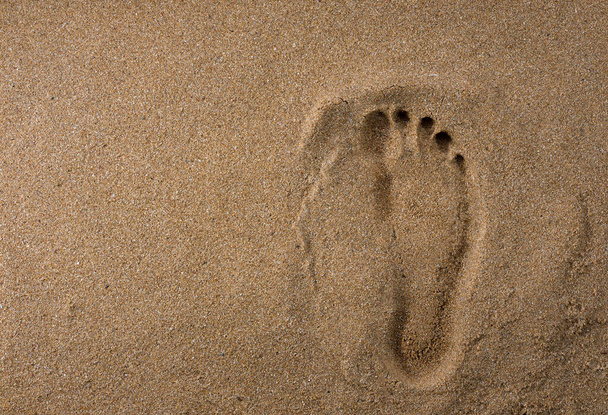 Ένα αποτύπωμα ποδιού σε υγρή άμμο. Άντρας στην παραλία - Φωτογραφία, εικόνα