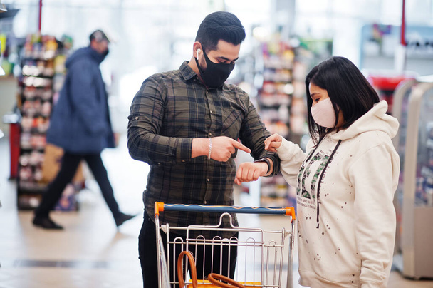 We have no time for that! Asian couple wear in protective face mask shopping together in supermarket during pandemic. - Fotografie, Obrázek