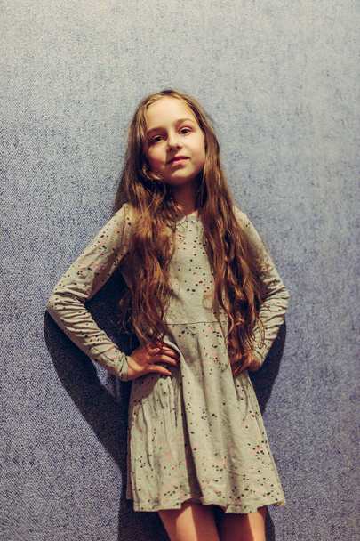 Tinédzser lány portré. Egy tinédzser lány portréja otthon. Hosszú hajú lány a falnak támasztva - Fotó, kép