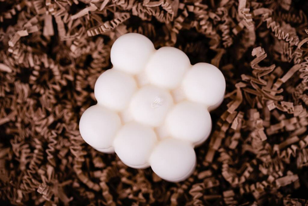 Közelkép a fehér buborék kocka gyertyák a barna aprított papír háttér - Fotó, kép