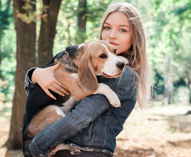 Cute girl with a beagle dog - Фото, зображення