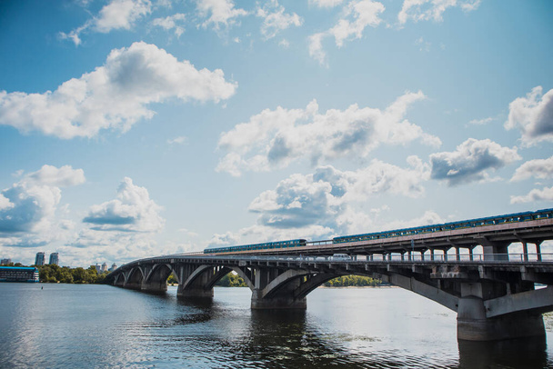 Zwei U-Bahn-Züge in Kiew fahren an einem warmen Sommertag in der Ukraine über die Brücke über den Dnjepr in Richtung Hydropark und Dnipro-Viertel. - Foto, Bild