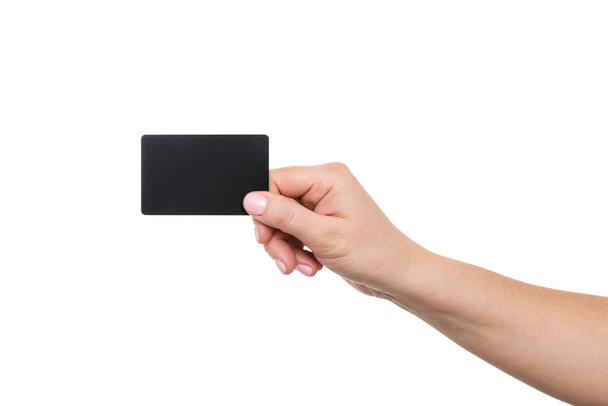Visitenkarte in weiblicher Hand, Nahaufnahme isoliert auf weißem Hintergrund. Nahaufnahme einer Frauenhand, die eine leere schwarze Karte hält. - Foto, Bild