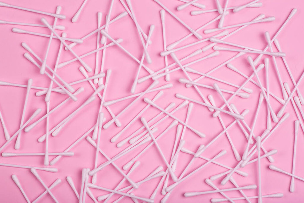 Plastic hygiene sticks on a pink background. Plastic pollution and hygiene waste concept. - Fotó, kép