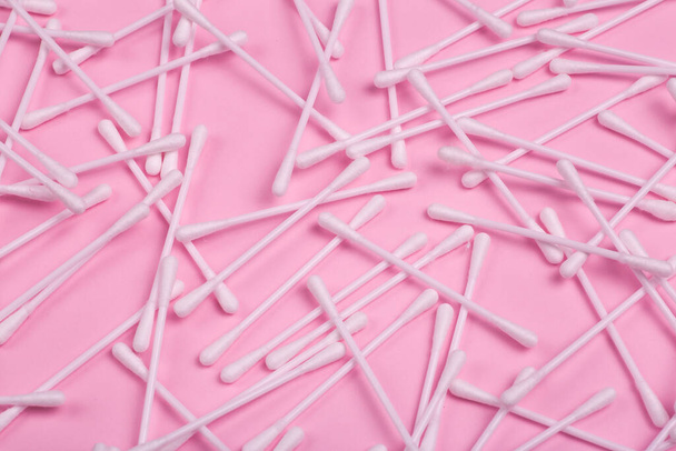 Plastic hygiene sticks on a pink background. Plastic pollution and hygiene waste concept. - Zdjęcie, obraz