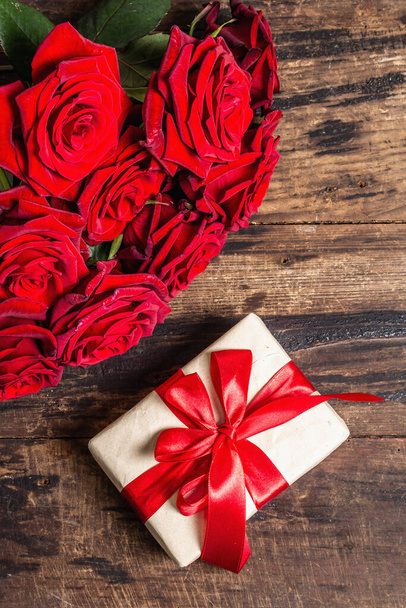 Valentine fundo cartão de saudação com uma caixa de presente e rosas borgonhas frescas. Mesa de madeira vintage. Conceito de casamento ou aniversário, lugar para texto, flat lay - Foto, Imagem