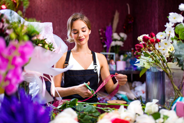 florist making bouquet for a client in store in spring day - Fotoğraf, Görsel