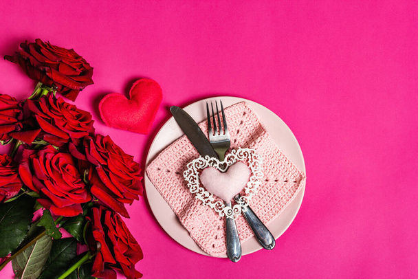 Romantic dinner table. Love concept for Valentine's or mother's day, wedding cutlery. Bouquet of fresh burgundy roses, handmade crochet napkin - Foto, Imagem