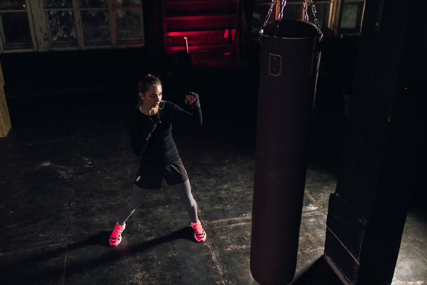 Cool female fighter in boxing bandages trains in gym. Mixed martial arts - Fotoğraf, Görsel