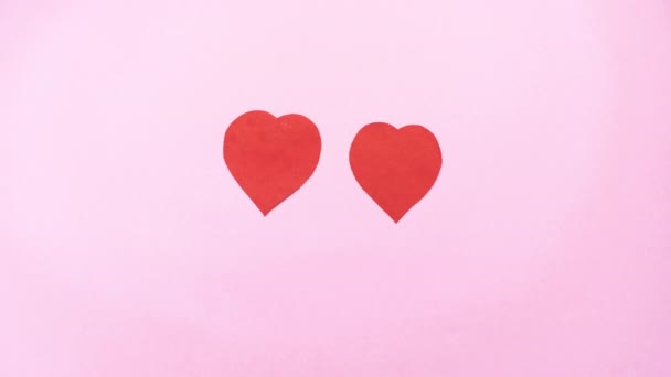 6k Meeting of two red hearts and the birth of love. Light pink background. Two hearts come closer to each other and unite into one. Stop motion animation. Valentines Day or wedding and love concept. - Footage, Video