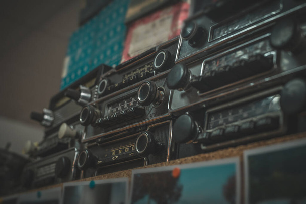 Anciennes radios de minuterie empilées sur une étagère. Collection style marché aux puces d'une autoradios rétro. - Photo, image