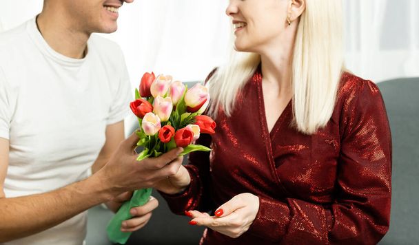 portrait of happy couple, husband and wife with spring flower bouquet - Photo, Image