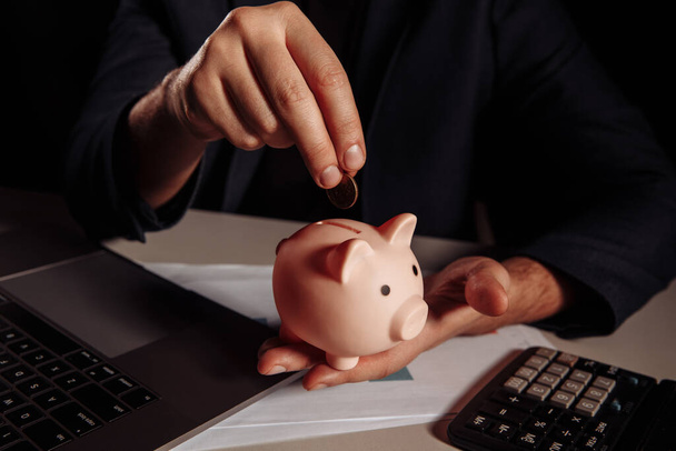 Man putting coin in piggy bank. Business and investment concept - Photo, Image