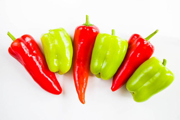 Перец и зеленый перец на белом фоне, красочные овощи, сырые ингредиенты - Фото, изображение
