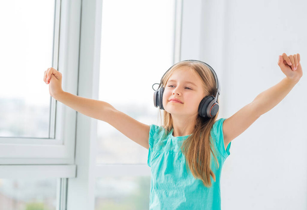 Little girl listening music in headphones - 写真・画像