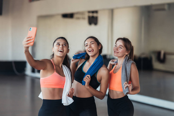 Two female friends taking a selfie photo after hard workout. - Photo, image