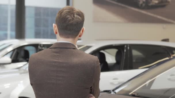 gelukkig volwassen man glimlachen naar de camera terwijl het kiezen van auto te kopen - Video