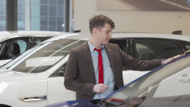 Dojrzałe mężczyzna klient badania nowoczesny samochód na sprzedaż w salonie - Materiał filmowy, wideo