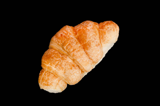 frisches goldenes Croissant auf schwarzem Backblech, leckeres Gebäck isoliert auf schwarzem Hintergrund - Foto, Bild