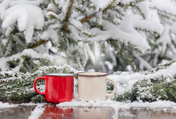 dos tazas de café en la mesa de madera en la nieve - Foto, imagen