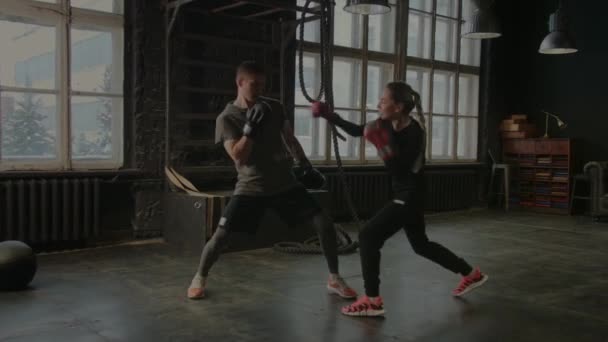 Boxeadores una chica y un hombre están luchando en el gimnasio - Imágenes, Vídeo