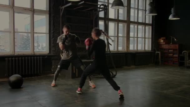 Boxeadores una chica y un hombre están luchando en el gimnasio - Imágenes, Vídeo