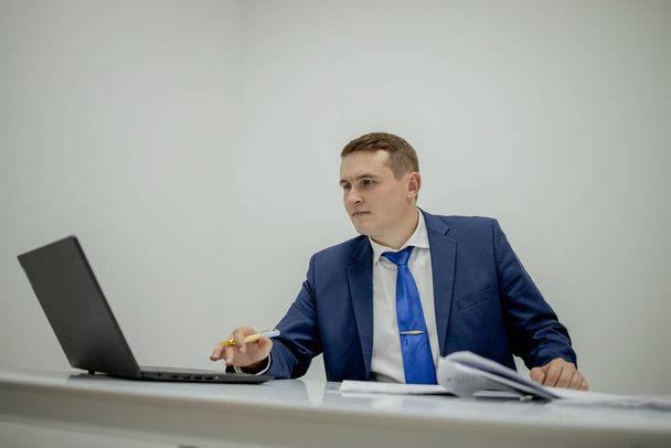 Young business man working at home with laptop and papers on desk. - Fotografie, Obrázek