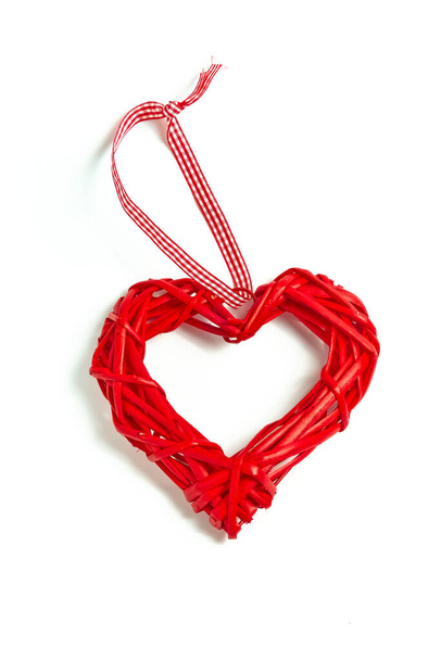 Beyaz arka planda el yapımı ağaç dallarından yapılmış kırmızı hasır kalp. Aşk tatili. Sevgililer Günü - Fotoğraf, Görsel
