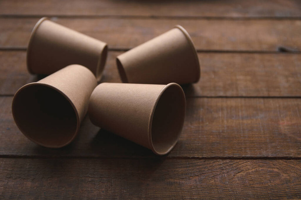 екологічні крафт-паперові чашки для кави та чаю темно-коричневі на столі
 - Фото, зображення
