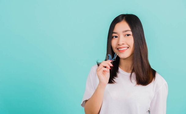 Portrait young Asian beautiful woman smiling holding silicone orthodontic retainers for teeth, Teeth retaining tools after removable braces, Orthodontics dental healthy care concept  - Photo, image