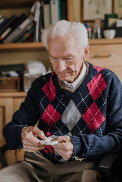 Старий тримає ліки бліді в руках
 - Фото, зображення