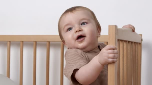 Lindo bebé en tela marrón que se queda en la cama en casa, de cerca, en cámara lenta - Imágenes, Vídeo