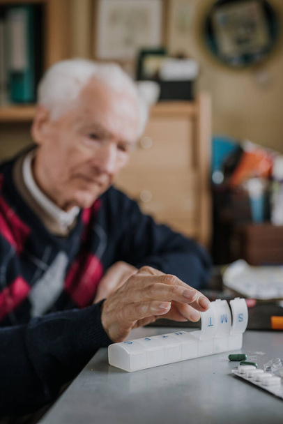 Senior besorgt Medikamente für jeden Wochentag - Foto, Bild