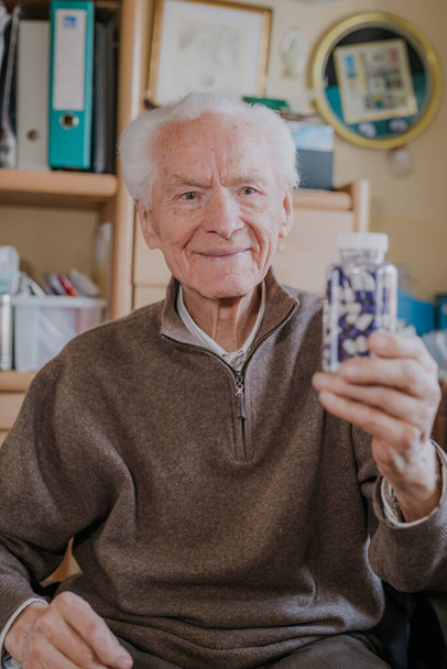 Senior man met fles met pillen close-up - Foto, afbeelding