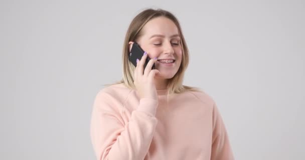 Chica hablando con entusiasmo en un teléfono celular - Metraje, vídeo
