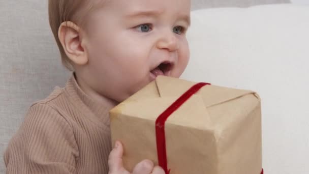 O primeiro presente. Bebê bonito brincando com a caixa de presente embrulhado, palmas, câmera lenta - Filmagem, Vídeo
