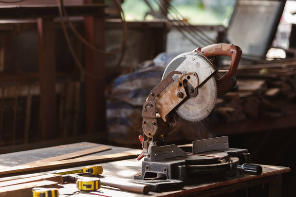 Sierra circular de carpintero sobre mesa con cinta métrica y astillas de madera en el lugar de trabajo de la fábrica de madera. - Foto, Imagen