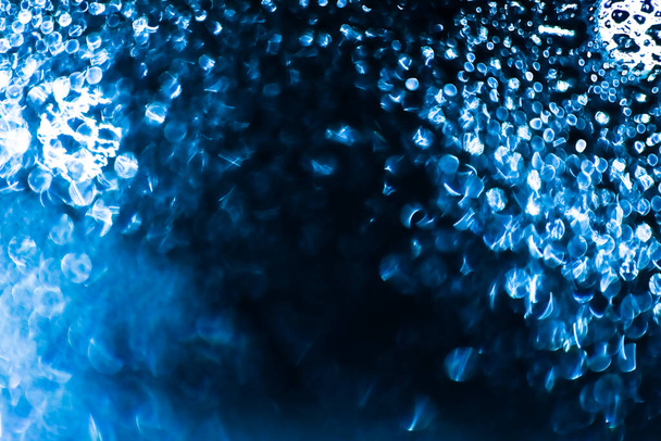 Gotas de agua y gotas de hielo en el fondo azul desenfocado. - Foto, Imagen