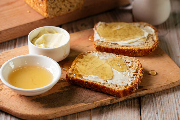 Whole grain bread slices with butter and honey - Photo, image
