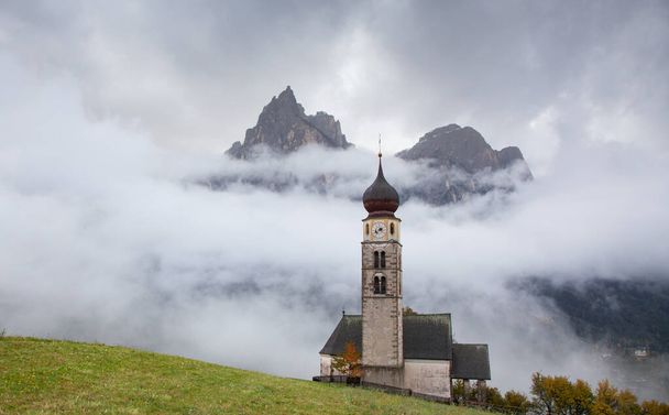 San Valentino church on a foggy late autumn day, Siusi allo Sciliar, Castelrotto, Dolomites, Italy - Фото, изображение