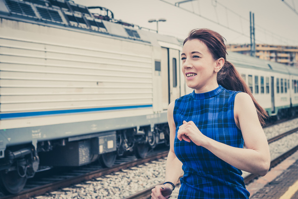 Pretty girl running along the tracks  - Foto, afbeelding