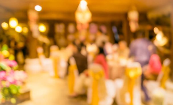 Imagen borrosa abstracta de Conjunto de mesa de comedor grande para bodas, cenas o eventos de festivales con hermosa decoración de luces dentro de un gran salón para uso de fondo. (tono vintage) - Foto, Imagen